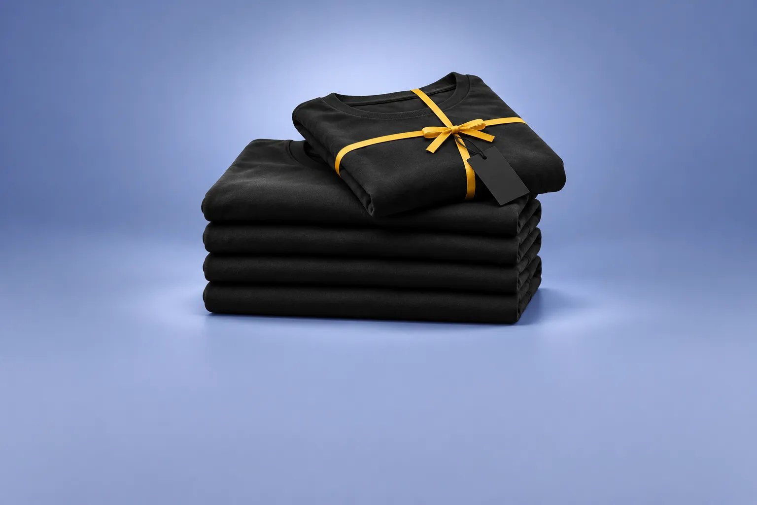 A stack of folded black T-shirts with one extra shirt tied with a yellow ribbon like a gift